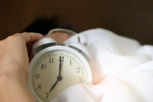 Photo of Person Holding Alarm Clock, waking up early