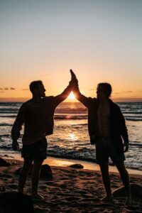 encouraging words for men, two men clapping each other on shore
