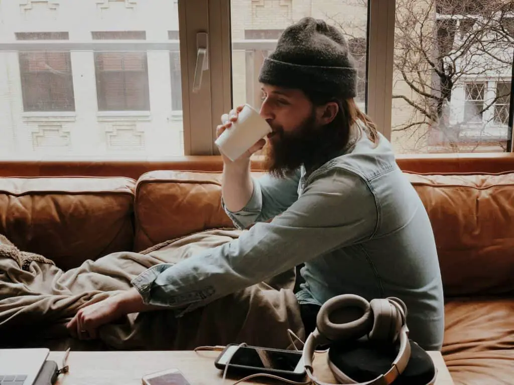 man sitting on sofa while drinking, morning