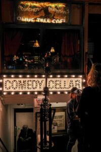 people standing best movies for laughter,outside of a building with a sign that says comedy cellar, best movies for laughter