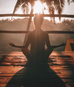 woman doing yoga meditation on brown parquet flooring, Self-Compassion