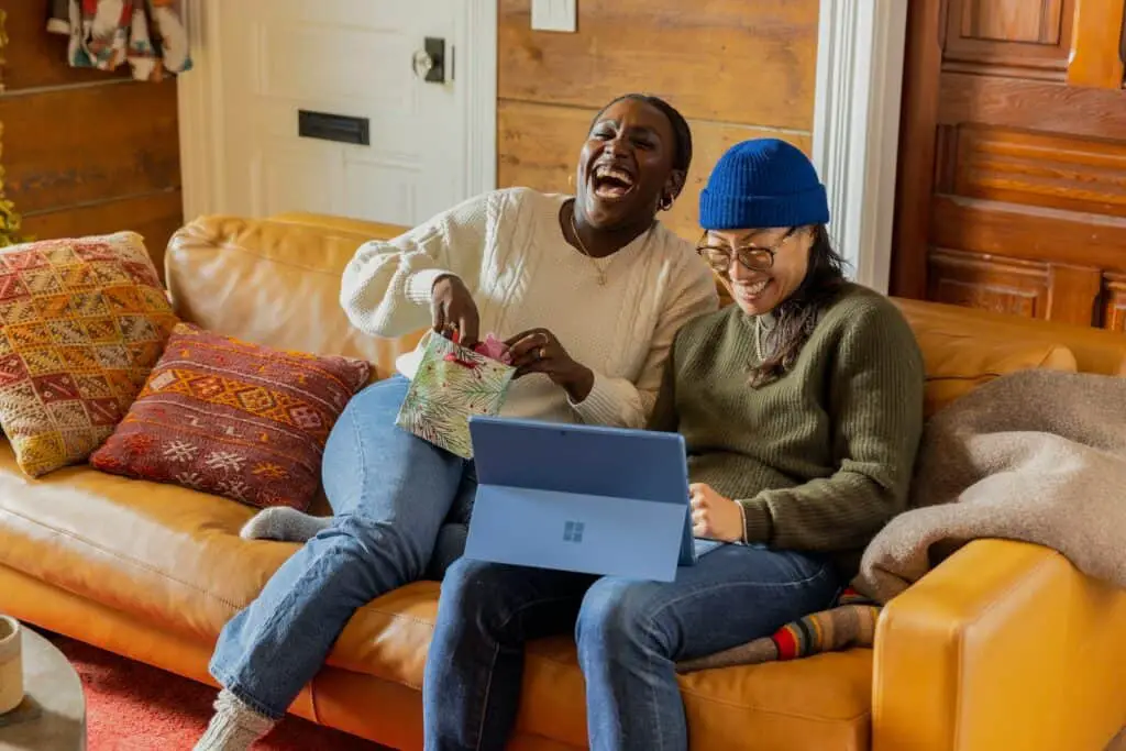 a person sitting on a couch with a laptop, happy