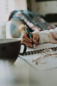 selective focus photography of person writing in journal