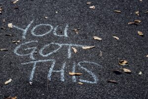 Chalk writing on paving that says You got this