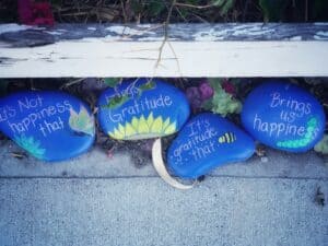 four painted rocks with words of gratitude written on them