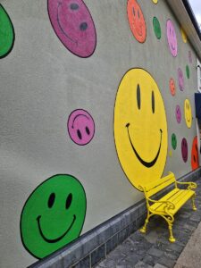 a wall with pictures of cartoon smiley faces painted on it